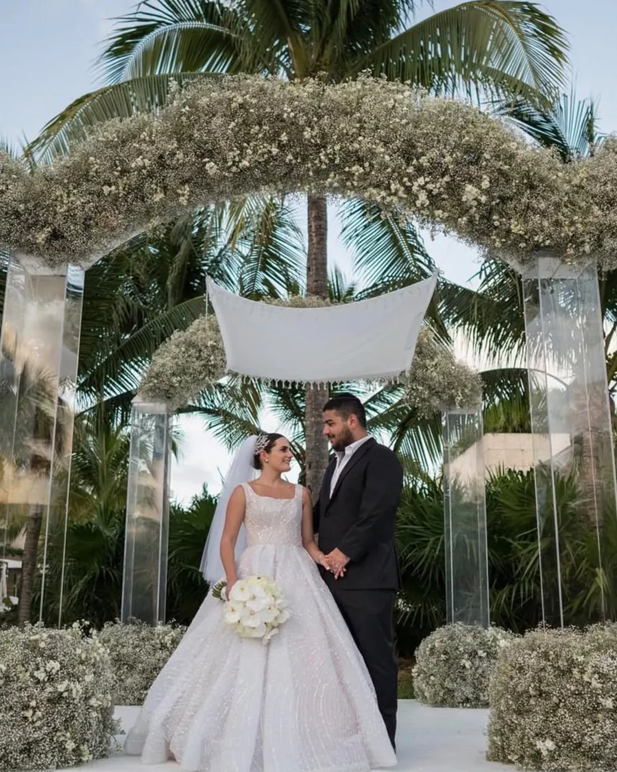 Novios bajo un arco floral en una boda en exterior