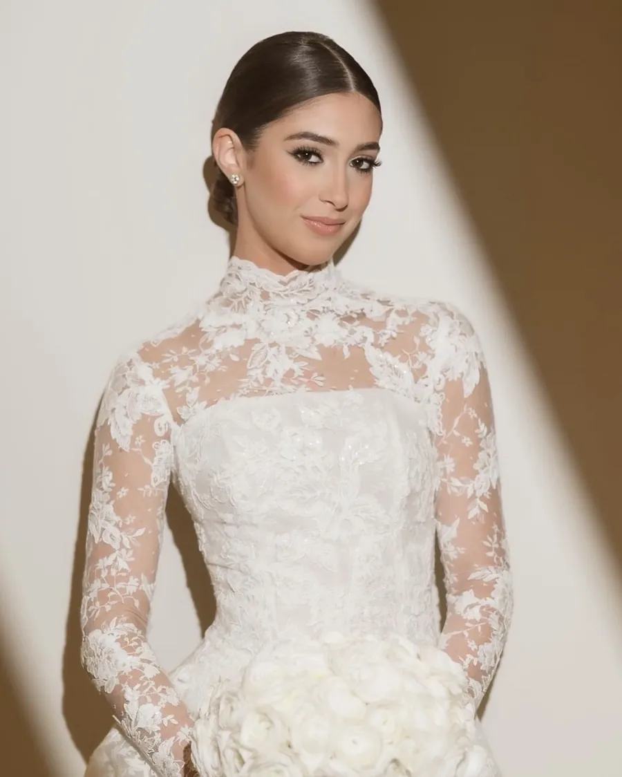 Novia con vestido de encaje y ramo blanco