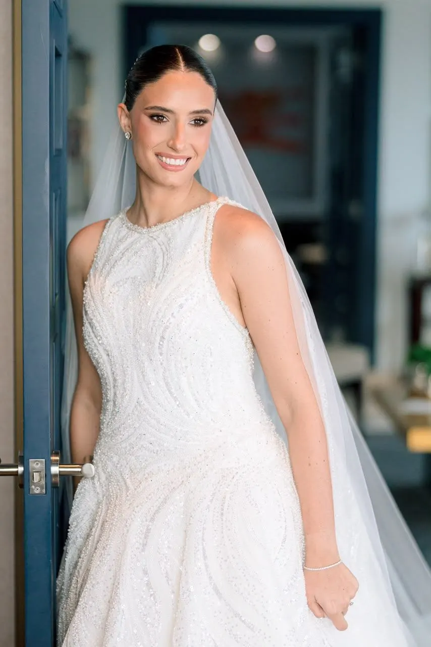 Novia con velo bordado mirando fuera de cámara